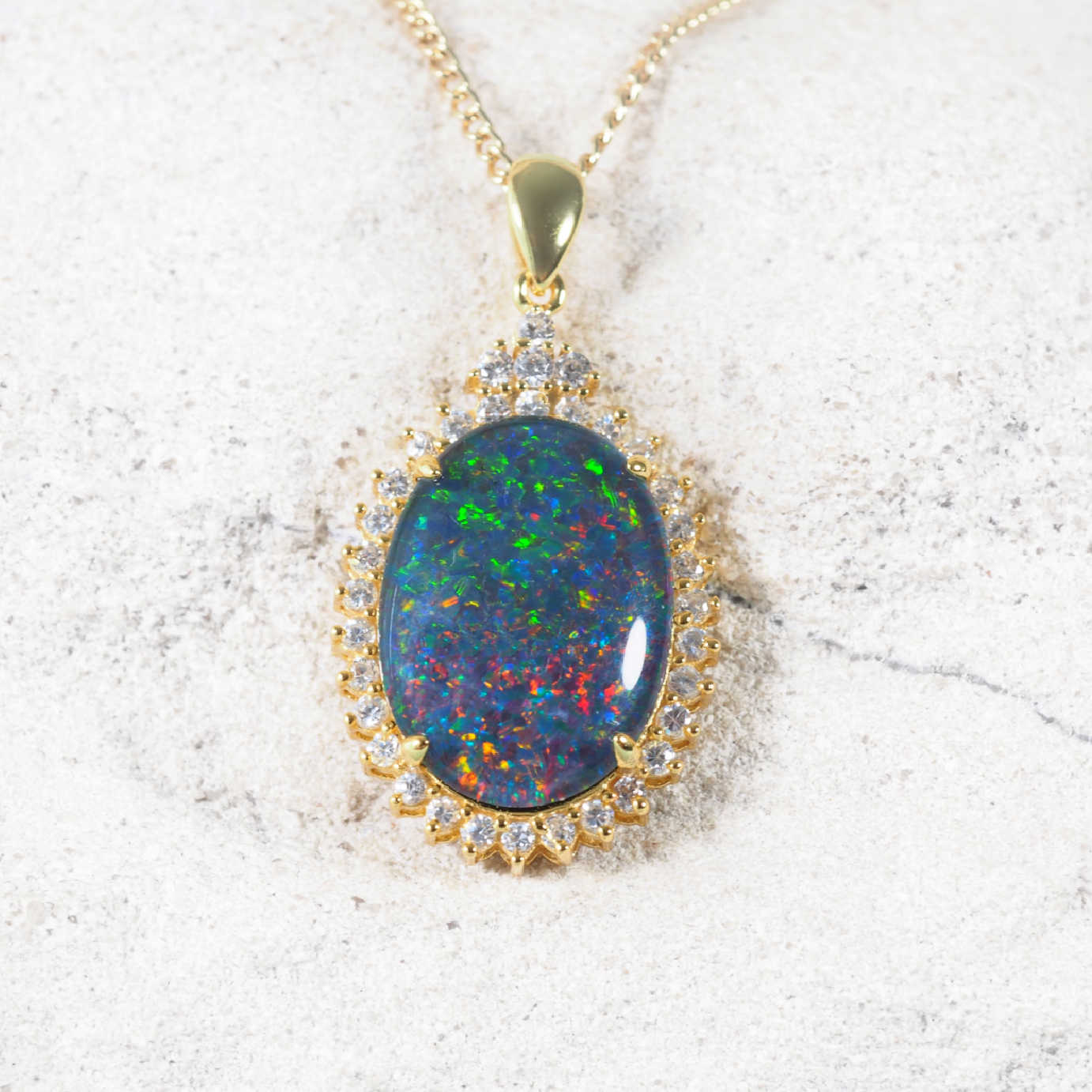 'Radiance' opal pendant in gold-plated silver with oval Australian triplet opal and halo of 34 sparkling diamantés