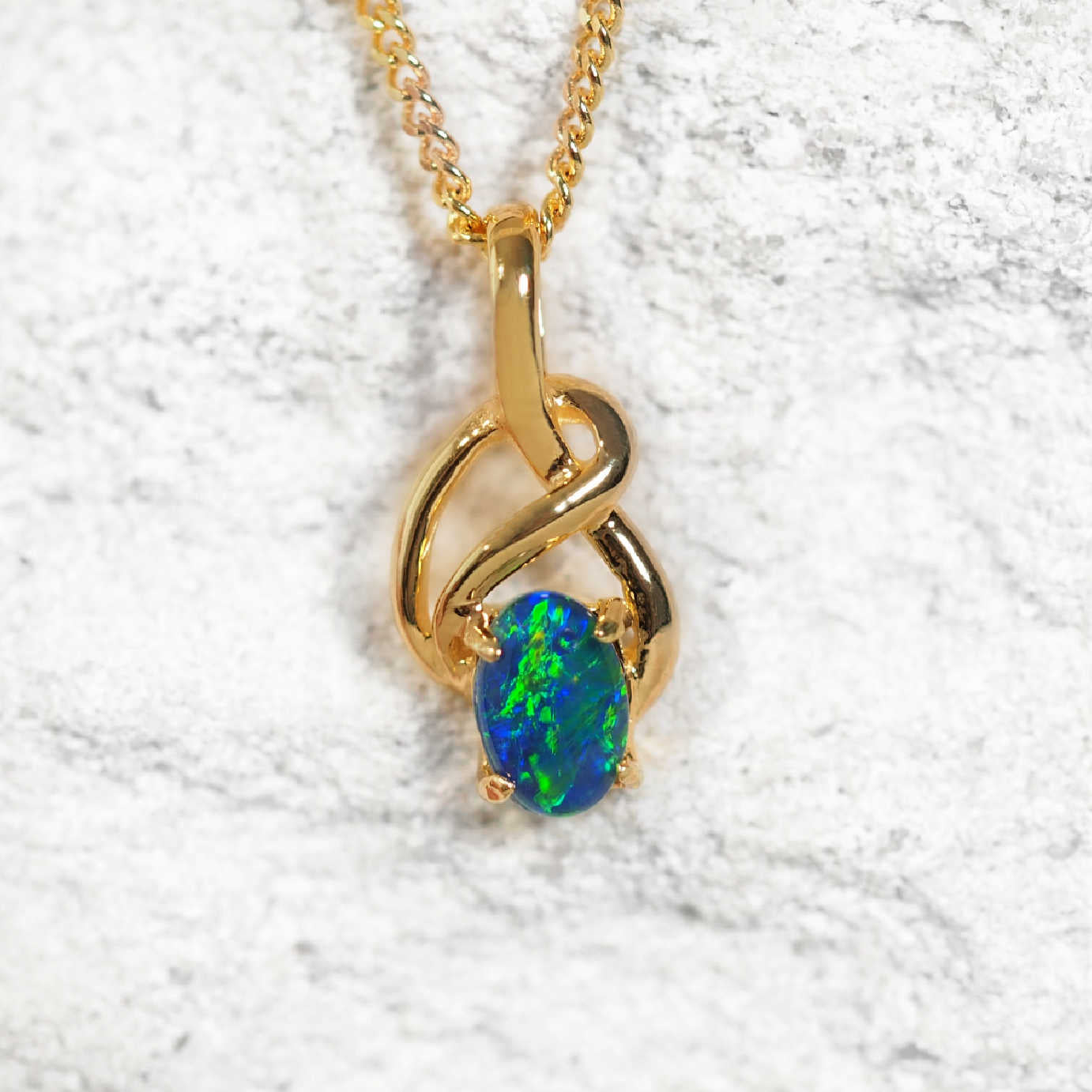 Eira Blue opal pendant in gold-plated silver with Celtic twist design and claw-set oval Australian triplet opal in blue and green tones
