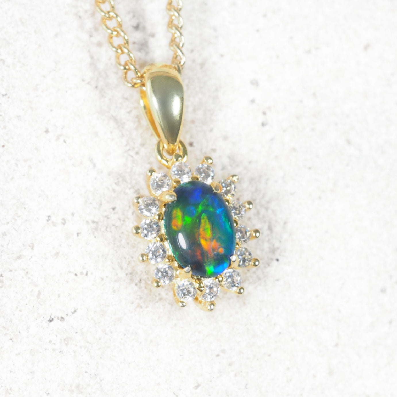 'Duchess' opal pendant in gold-plated silver with claw-set oval Australian triplet opal and halo of 14 sparkling cubic zirconias