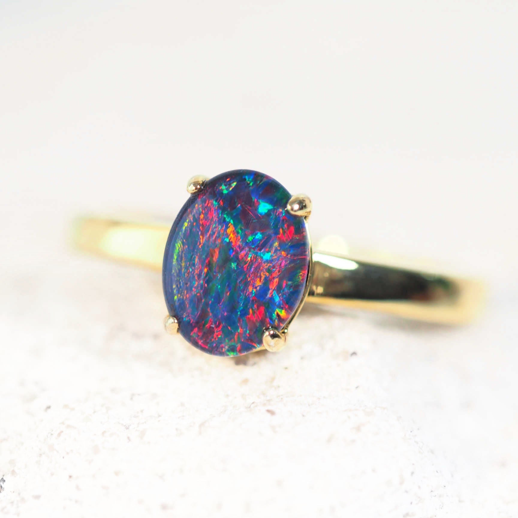 Ring with a colorful opal stone on a light background
