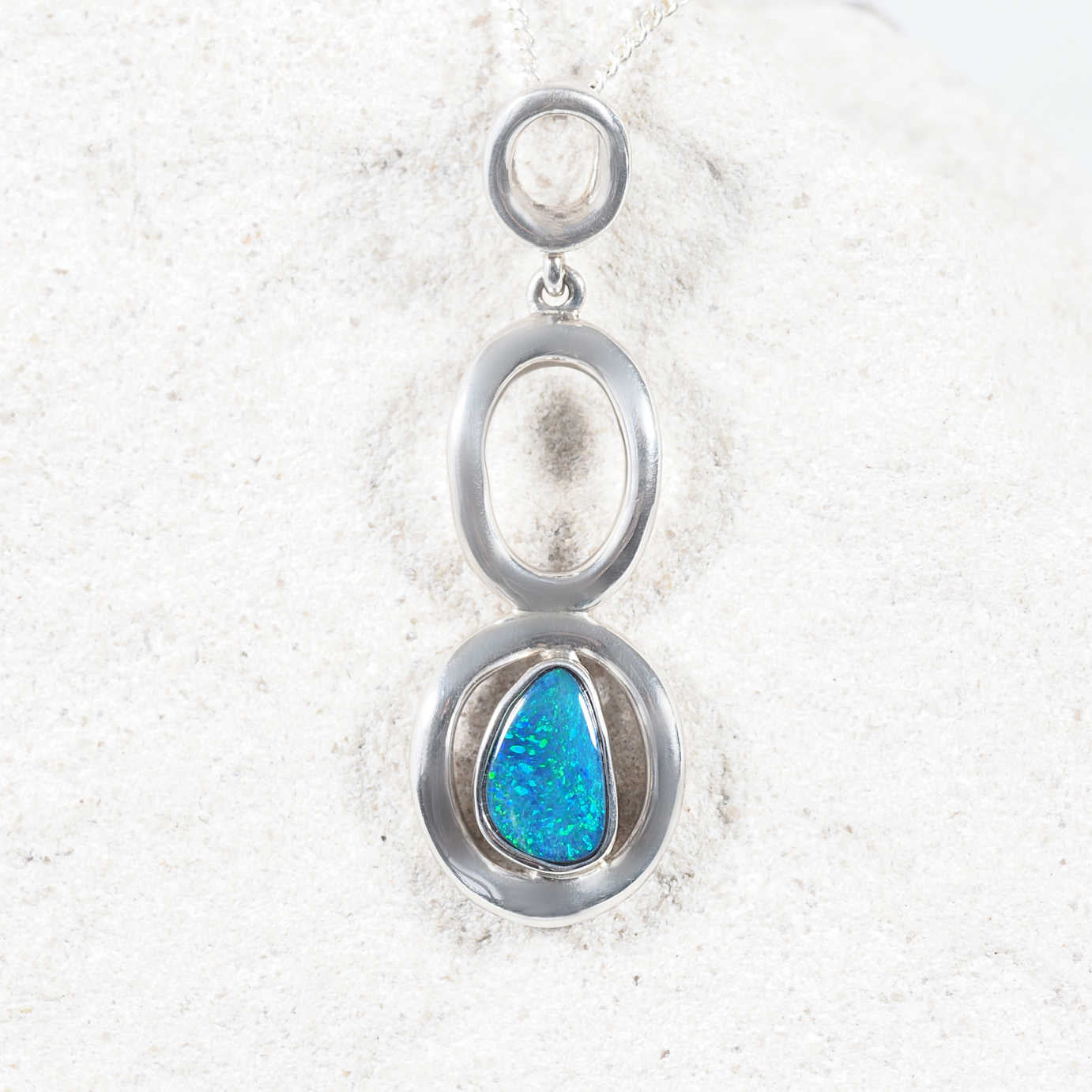 Sterling silver opal pendant with vibrant blue-green Australian doublet opal and halo setting