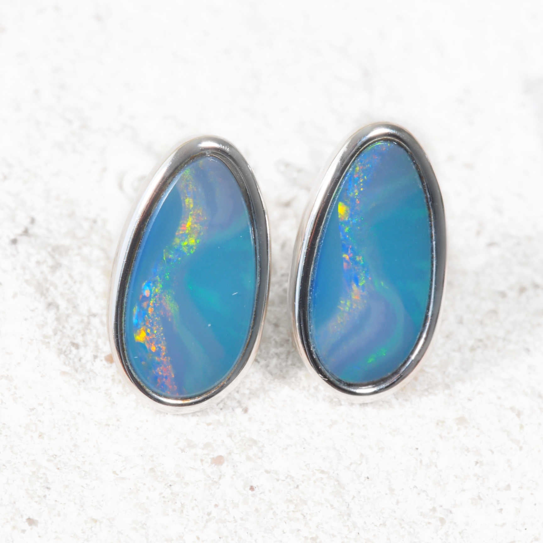 Opal earrings with a blue and purple color on a white background