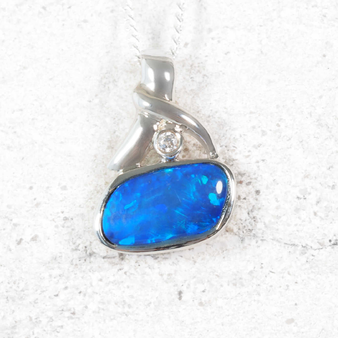 Blue pendant with a diamond on a white background