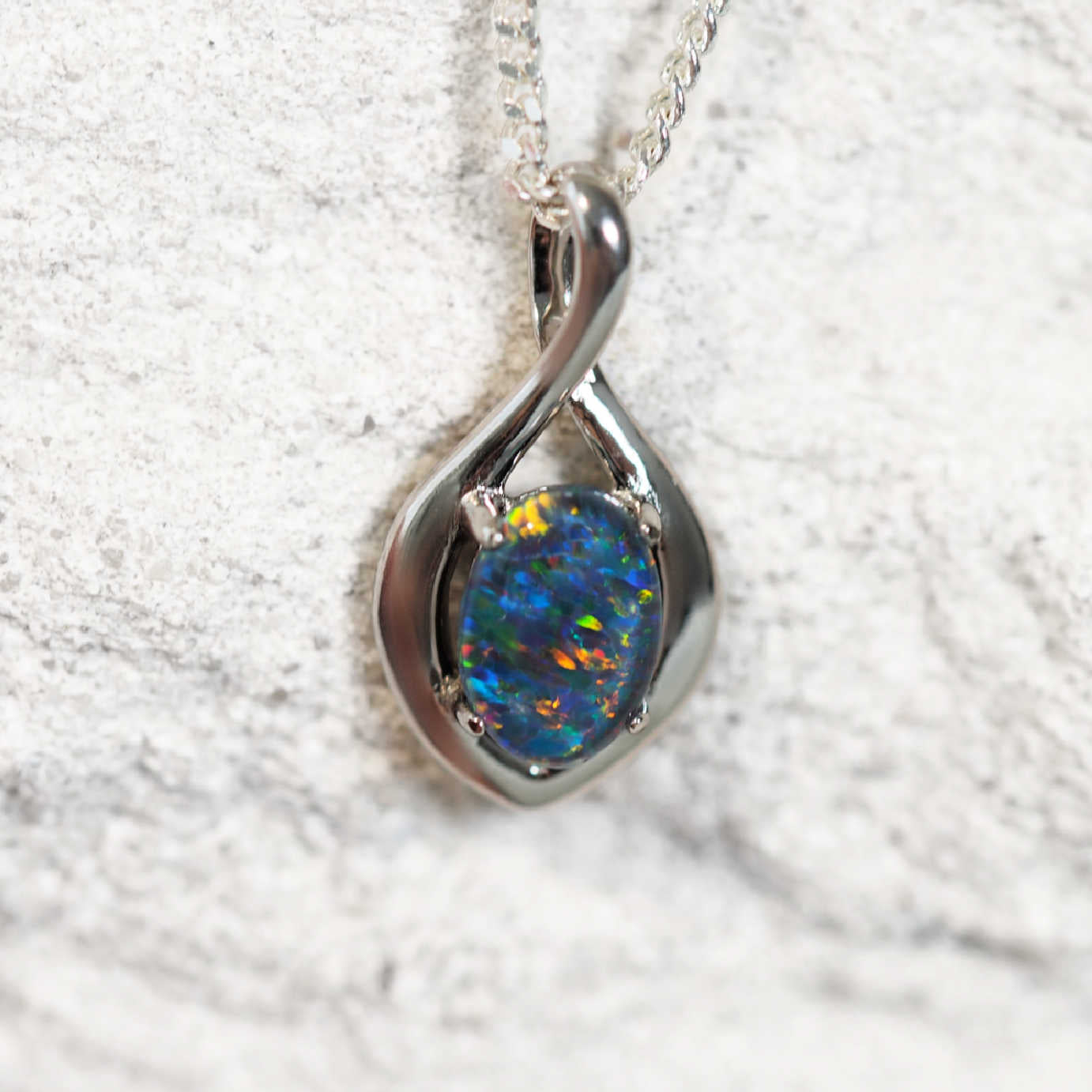 'Lira' opal pendant in sterling silver with claw-set oval Australian triplet opal in vibrant multi-colour ones
