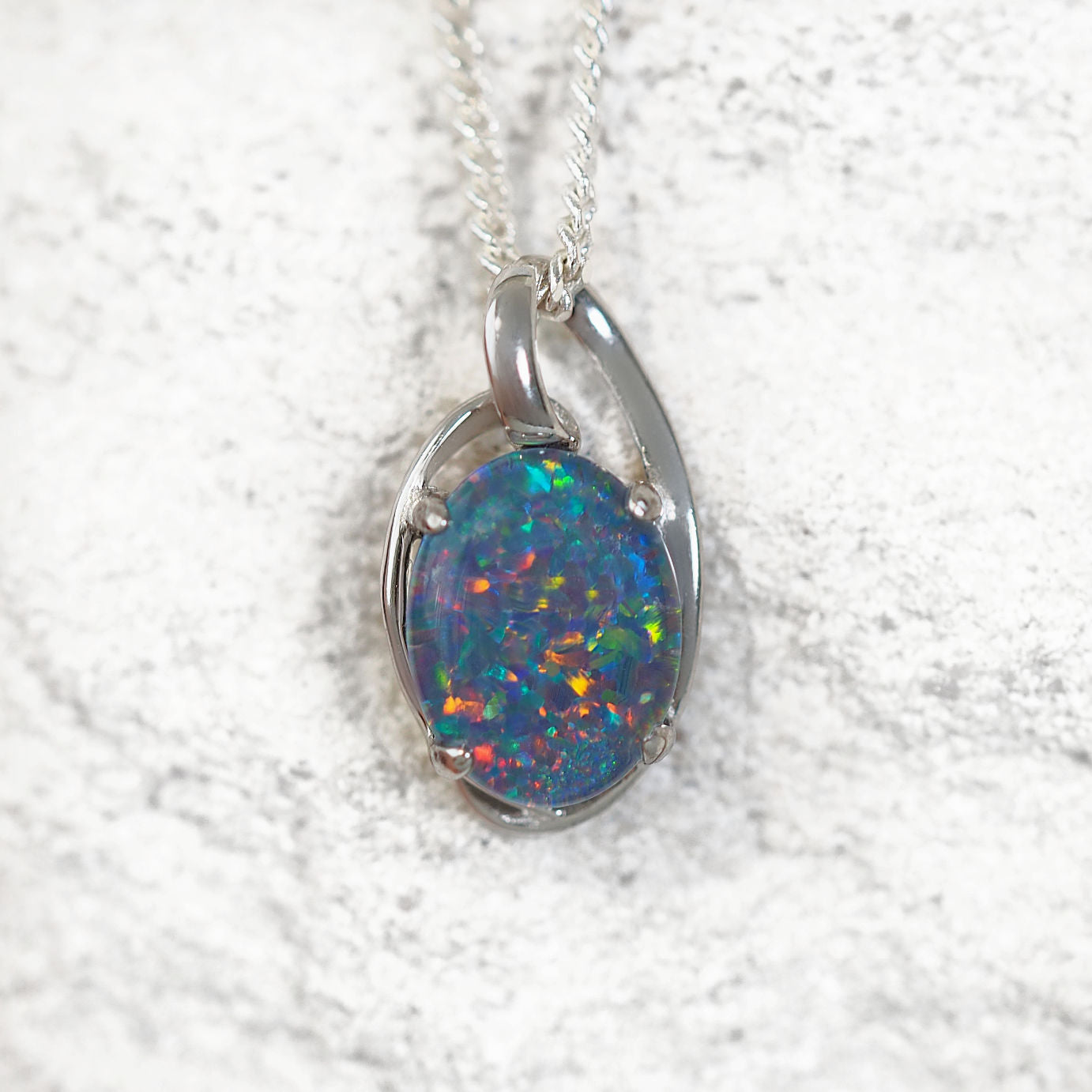 'Kylan' opal pendant in sterling silver with claw-set oval Australian triplet opal showcasing vibrant multi-coloured flashes