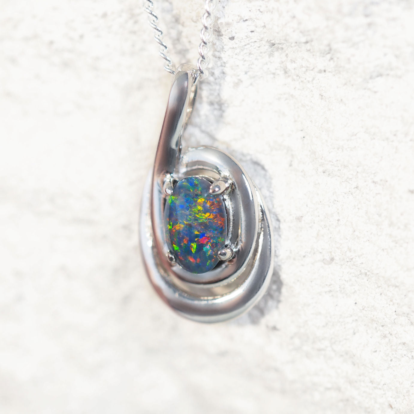 'Vianna' opal pendant in sterling silver with artistic double swirl design and claw-set oval Australian triplet opal in vibrant multi-coloured tones