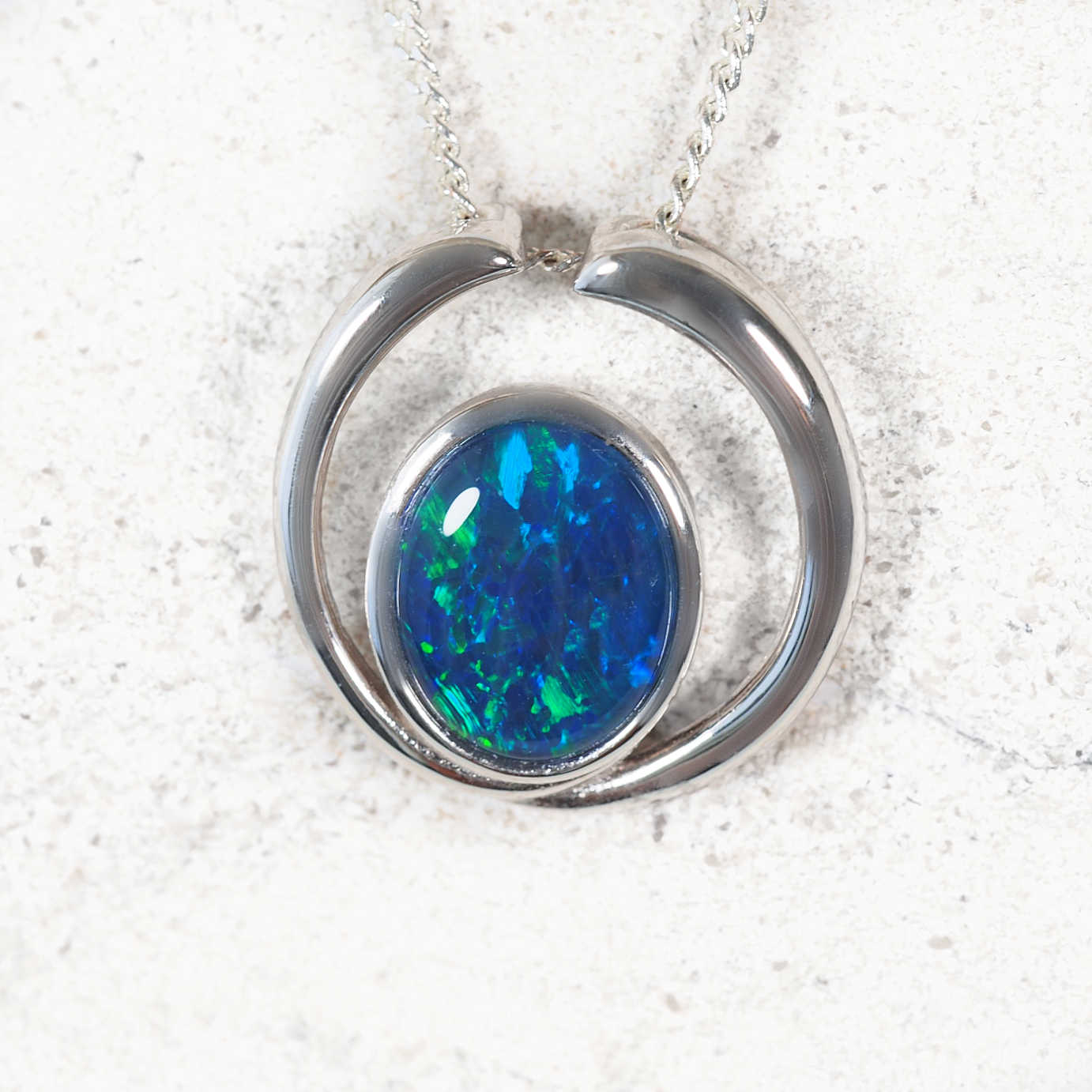 ‘Elana Blue Grande’ sterling silver open circle opal pendant with bezel-set oval Australian triplet opal in vibrant blue and green tones