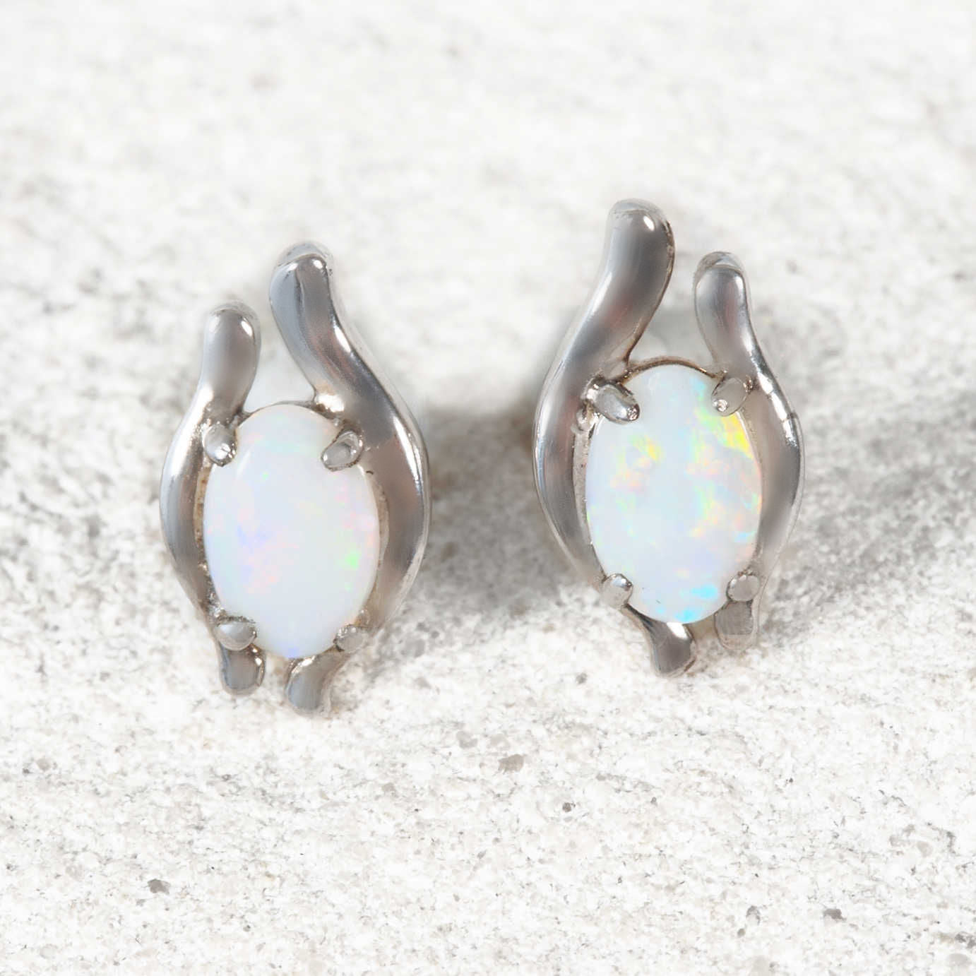 Sterling silver stud opal earrings featuring oval South Australian solid crystal opals with vibrant multi-coloured flashes.