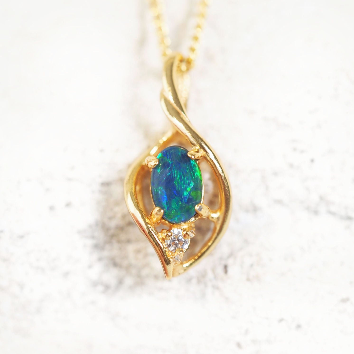 "Alani Blue opal pendant with oval blue and green triplet opal and cubic zirconia in gold-plated silver."