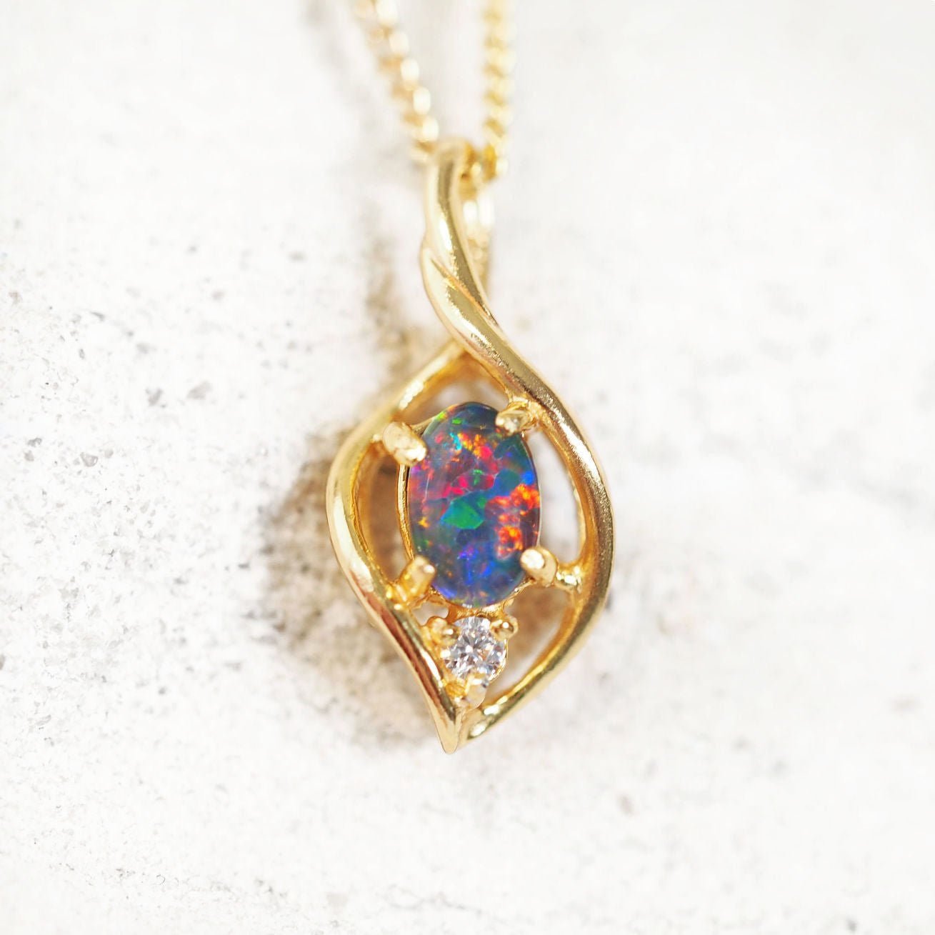 Gold-plated silver opal necklace pendant featuring an oval-shaped multi-coloured Australian triplet opal with a sparkling cubic zirconia accent.