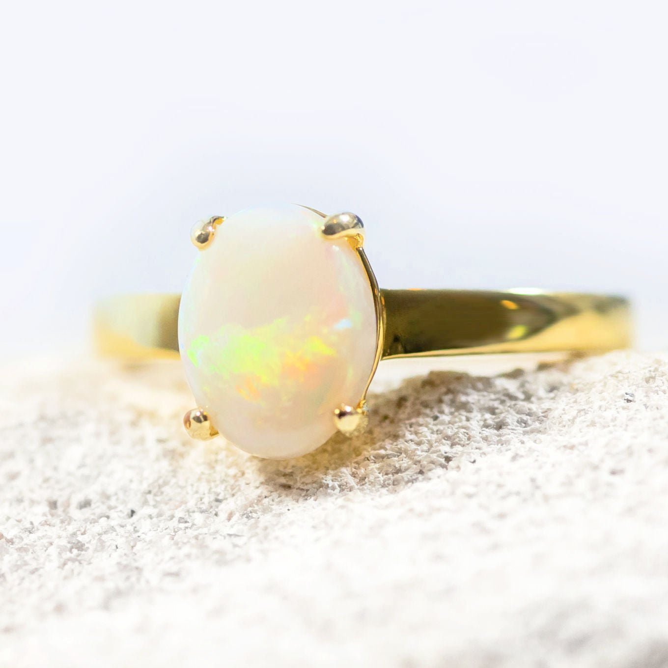 white opal gold plated silver ring set with a multi-colour solid opal