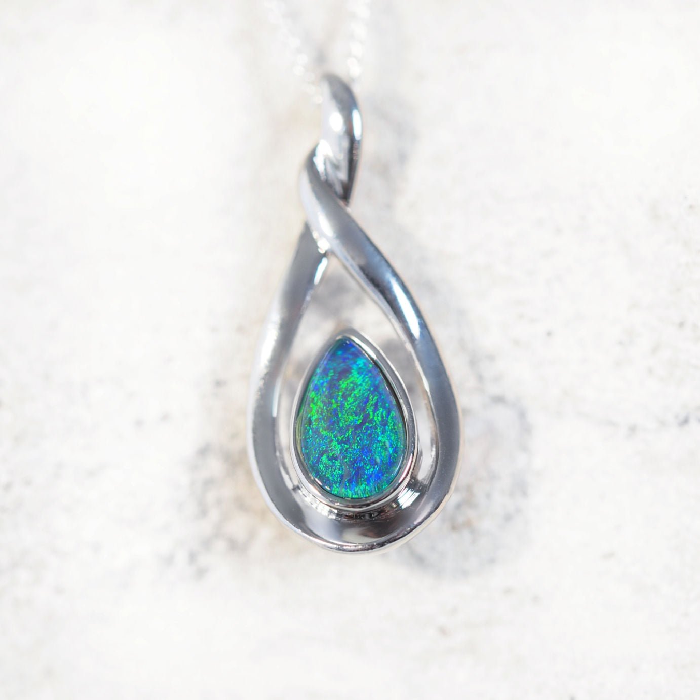 'Alison Blue' opal pendant in sterling silver with elegant twist design and bezel-set teardrop Australian triplet opal in vivid blue and green tones