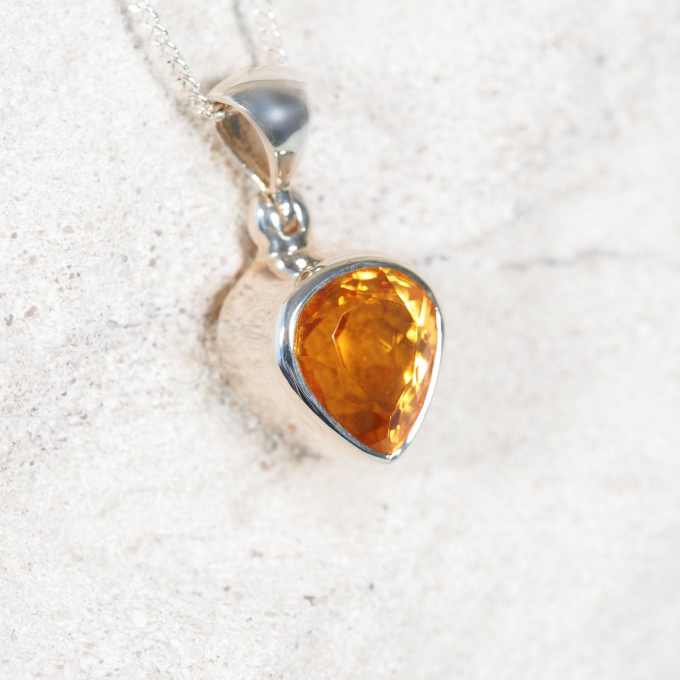 Close-up of "Amy' pendant highlighting faceted Brazilian Citrine in a polished silver setting