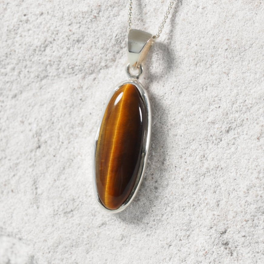 Tiger-eye Pendant displayed on a silver chain w