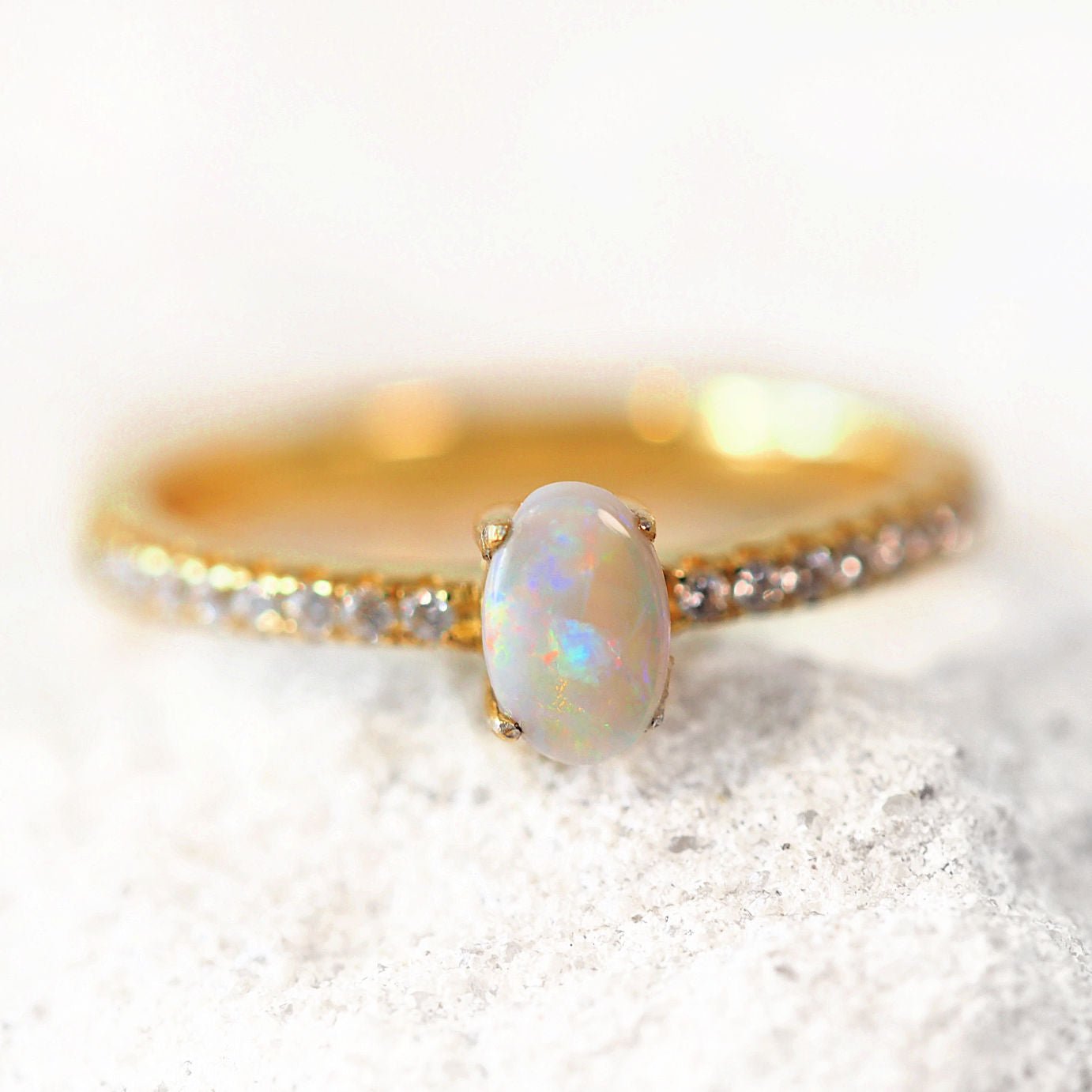 Gold ring with an opal stone on a white background