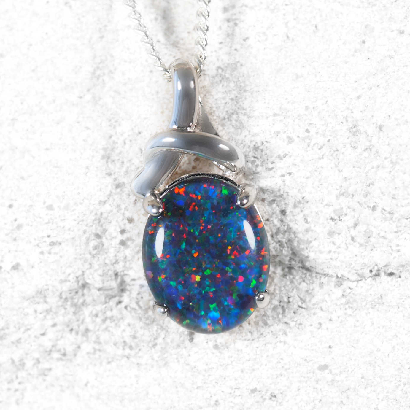 Opal pendant with silver setting on a white background