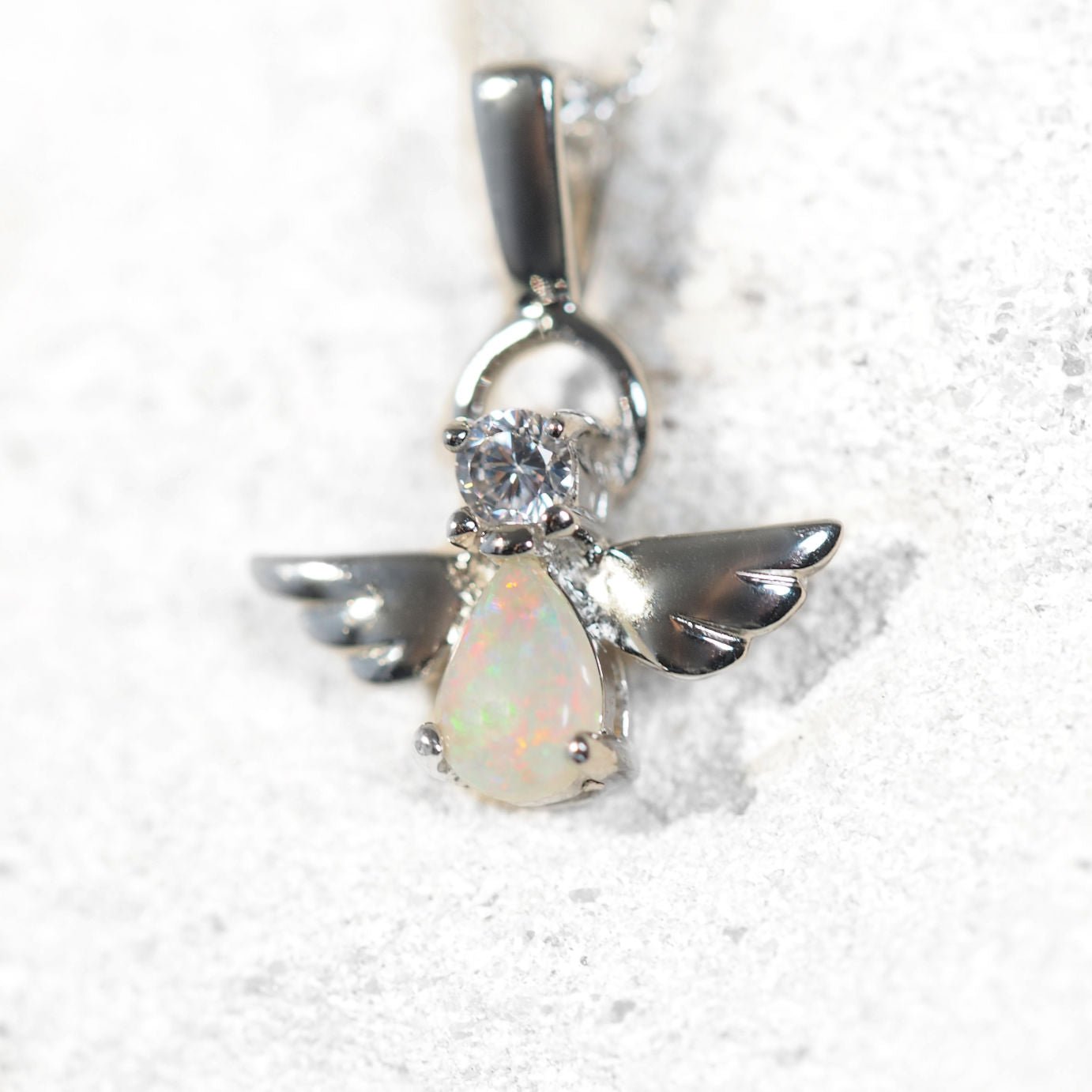 Silver angel opal pendant with clear gemstone on a white background