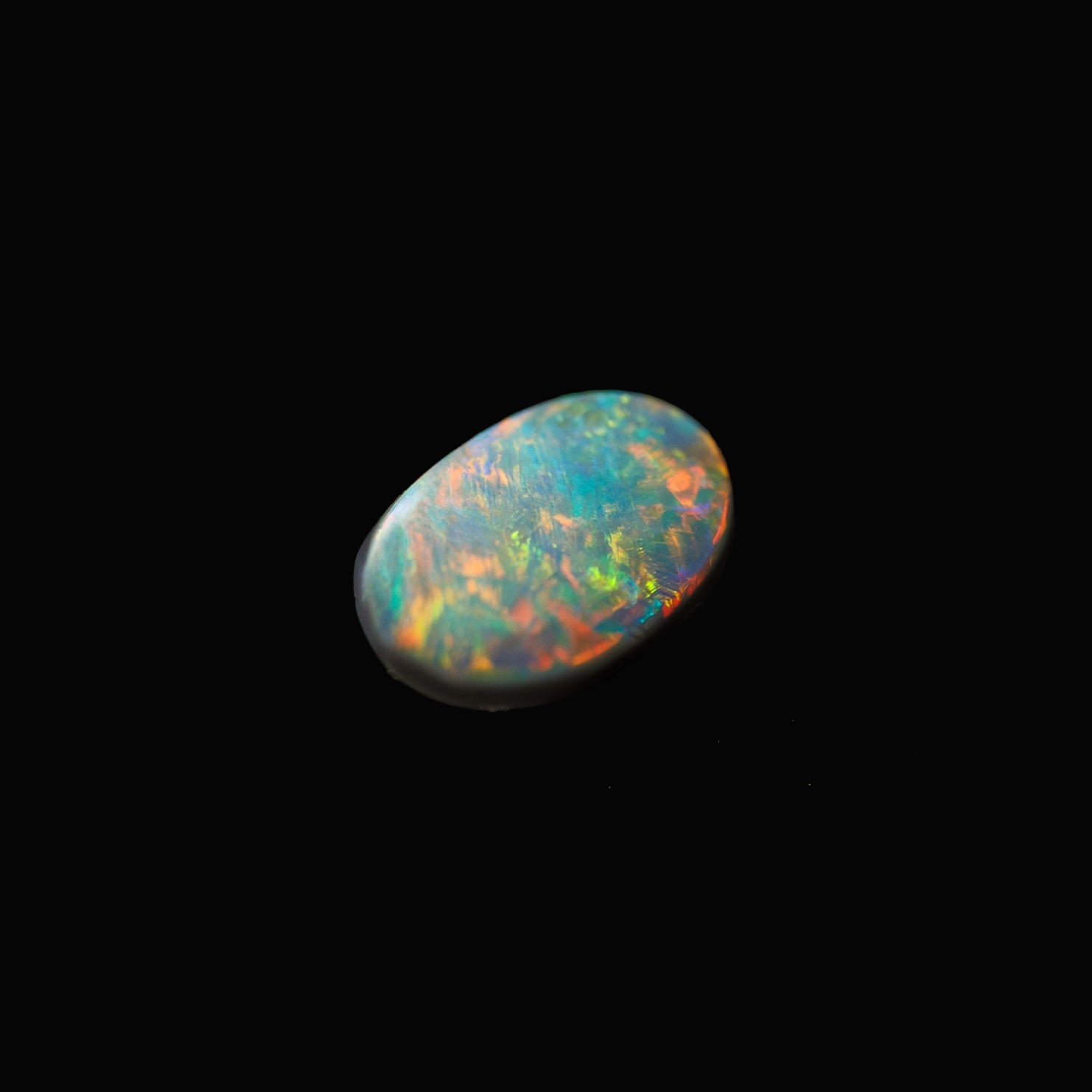Oval black opal gemstone from Lightning Ridge with vivid red, green, and blue play-of-colour