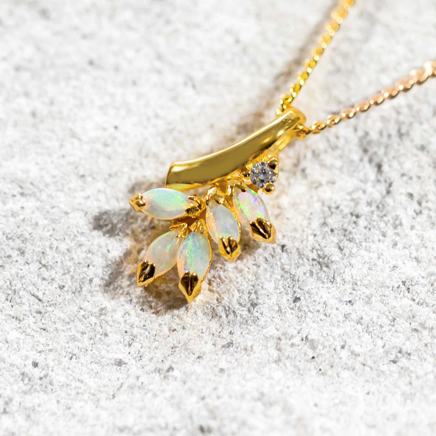 five colourful opals set into a necklace with a diamante