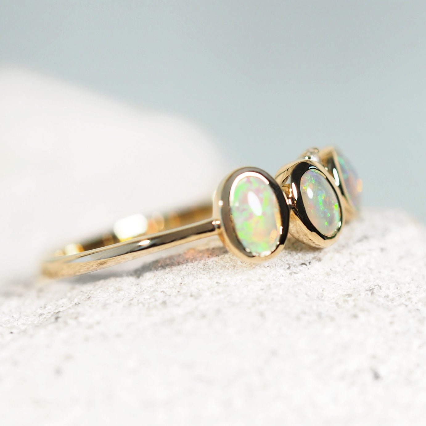 Elegant gold opal ring with bezel-set crystal opals and single white diamond