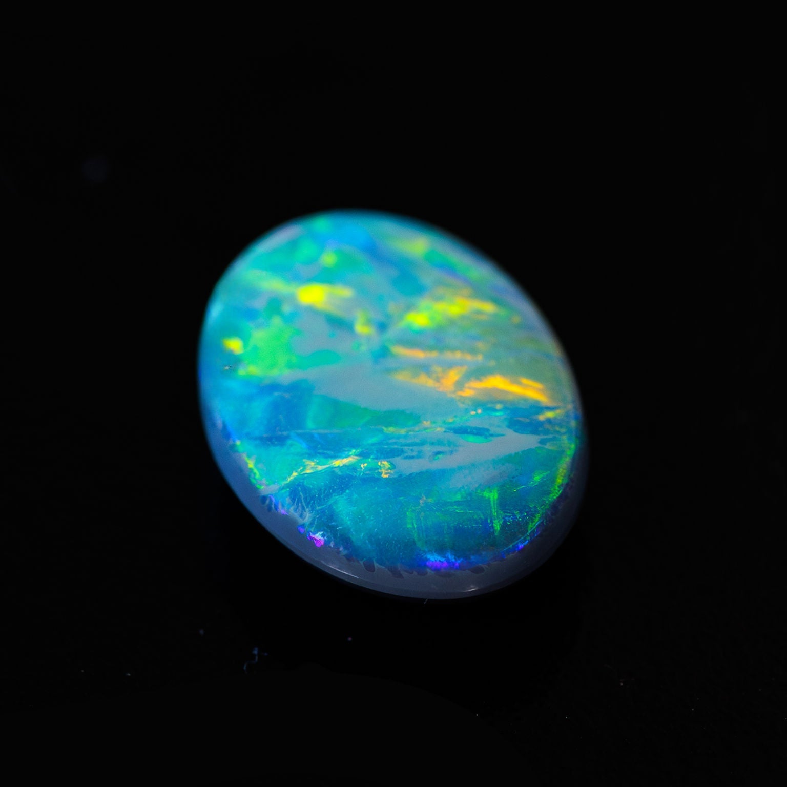 Close-up of oval opal gemstone with radiant play-of-colour