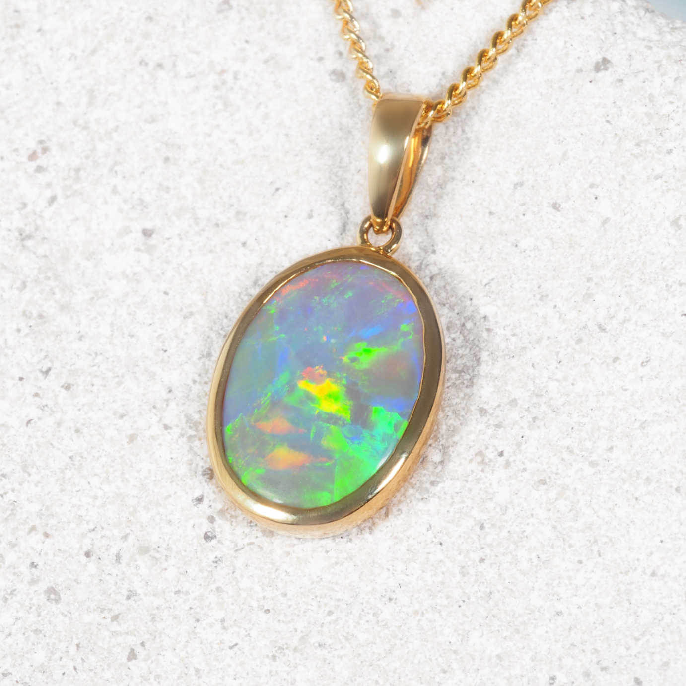 Black opal pendant necklace on a textured white background
