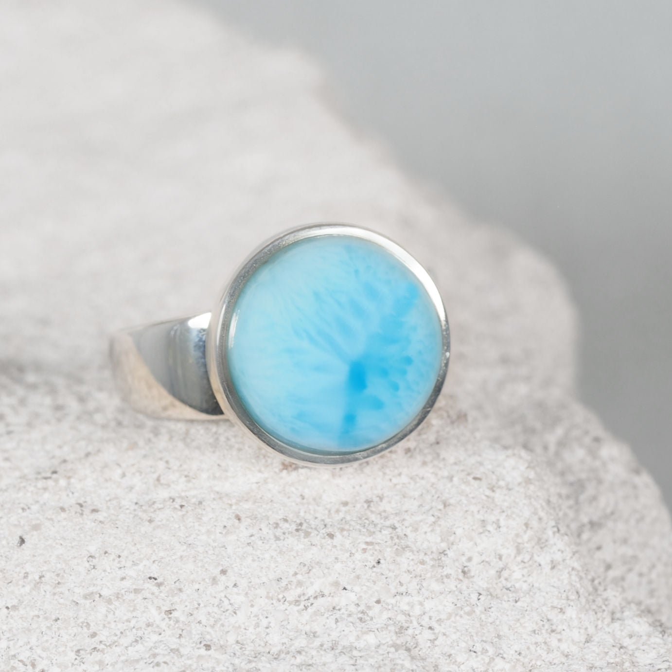 Circular Larimar silver ring showcasing a smooth blue cabochon with a sleek, modern design