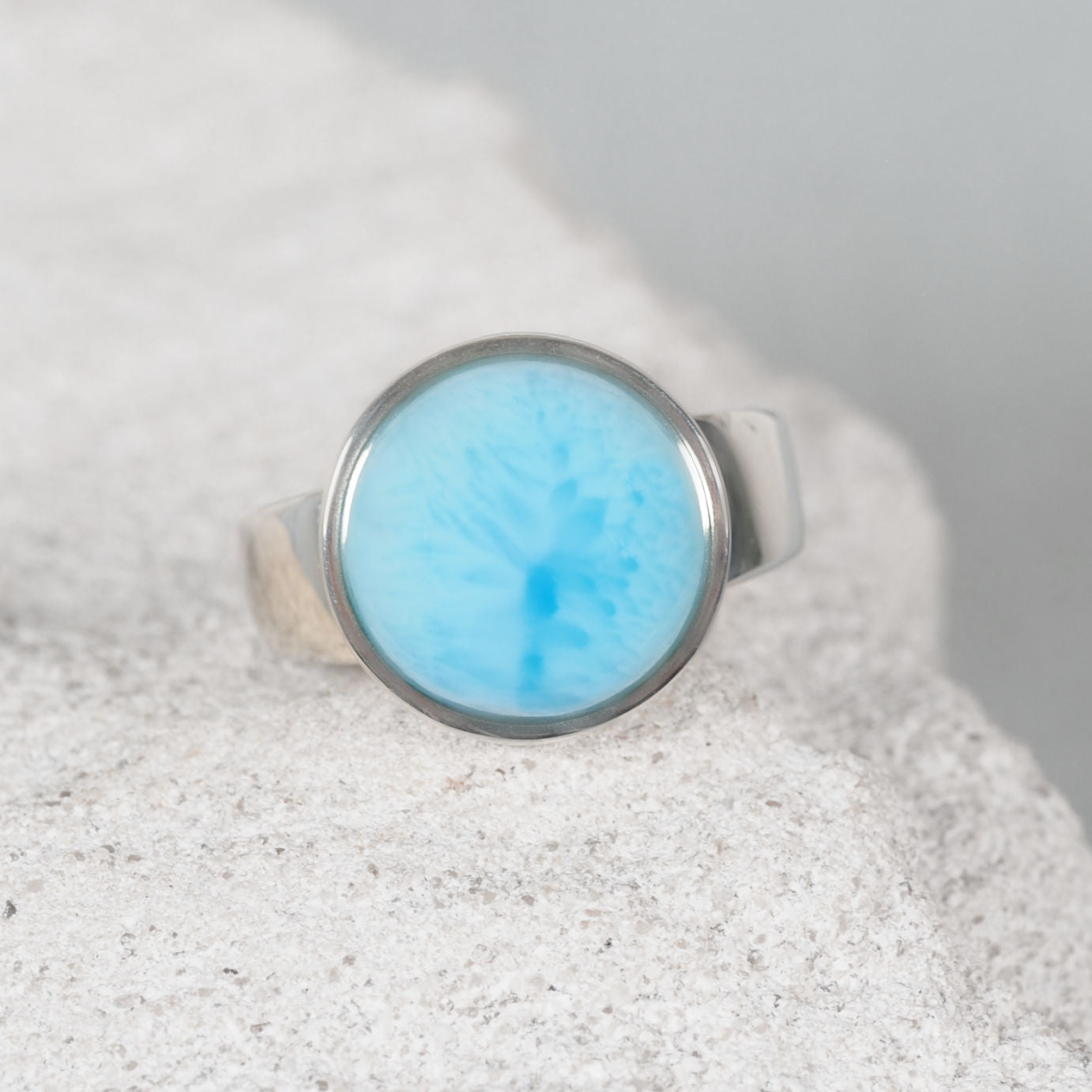 Close-up of the ‘Ayla’ Blue Larimar ring with a round blue gemstone set in a polished silver bezel