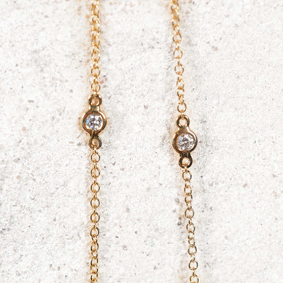 Gold chain necklace with two bezel-set diamonds