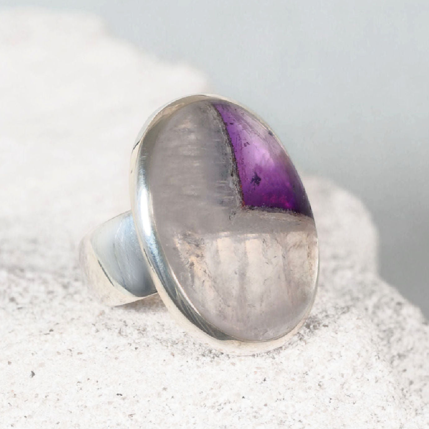 Elegant silver amethyst ring with a polished oval cabochon amethyst displaying subtle purple detail.