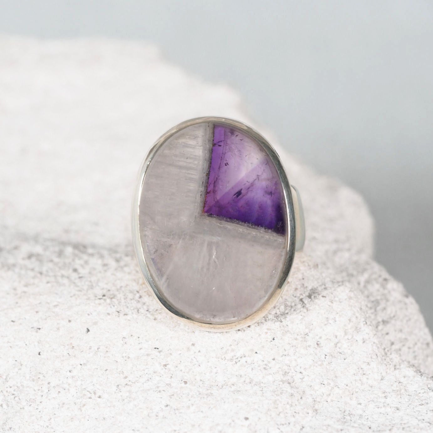 Silver bezel-set ring  ‘Bethany,’ featuring a smooth round amethyst cabochon with clear and purple tones.