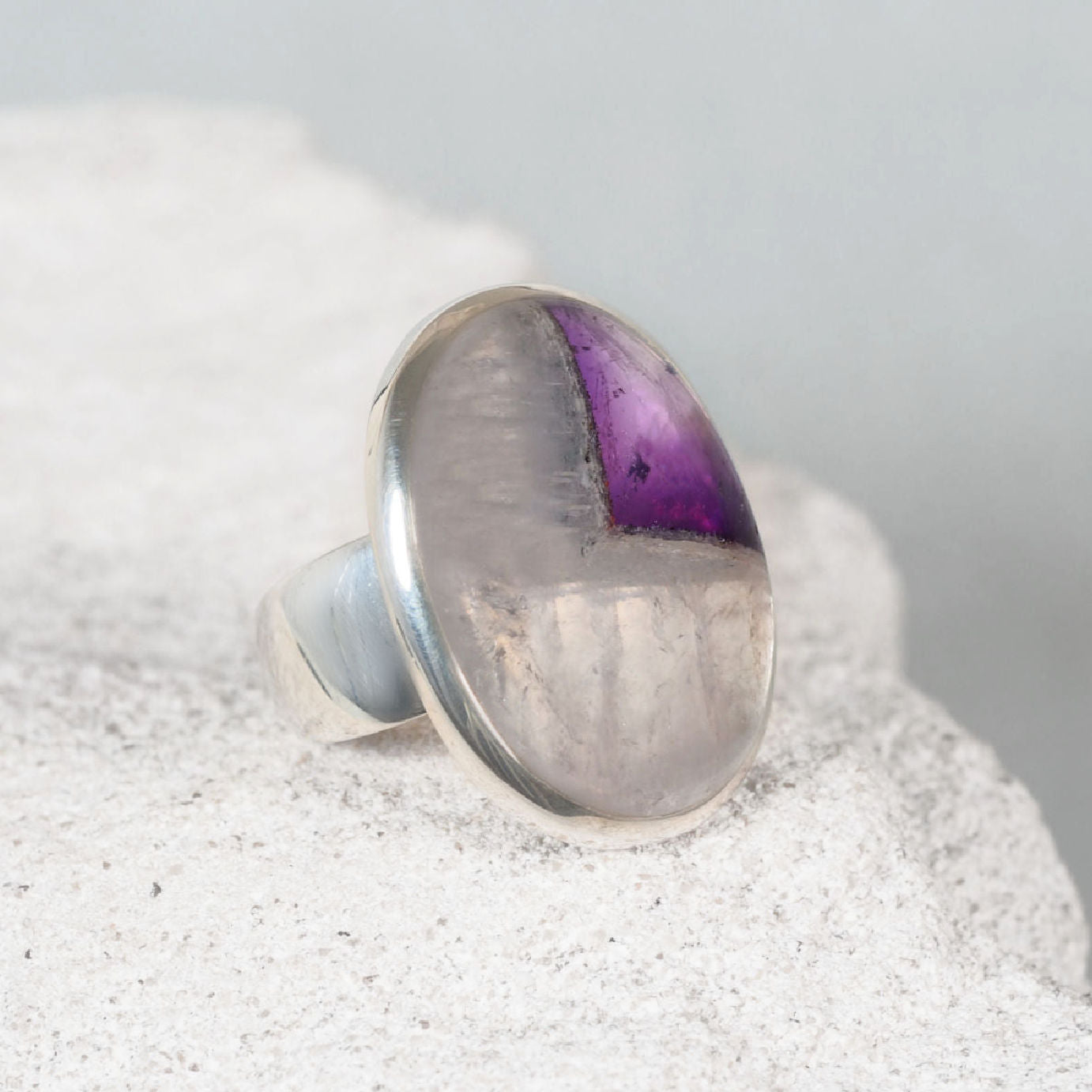 Elegant silver ring, the ‘Bethany,’ with a polished round cabochon amethyst displaying subtle purple detail.
