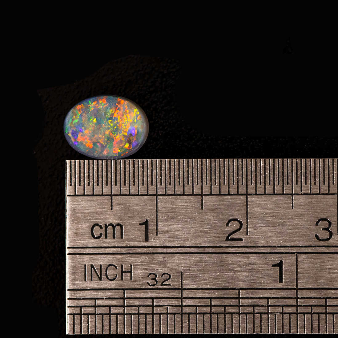 Oval-shaped Australian black opal displaying vivid color play
