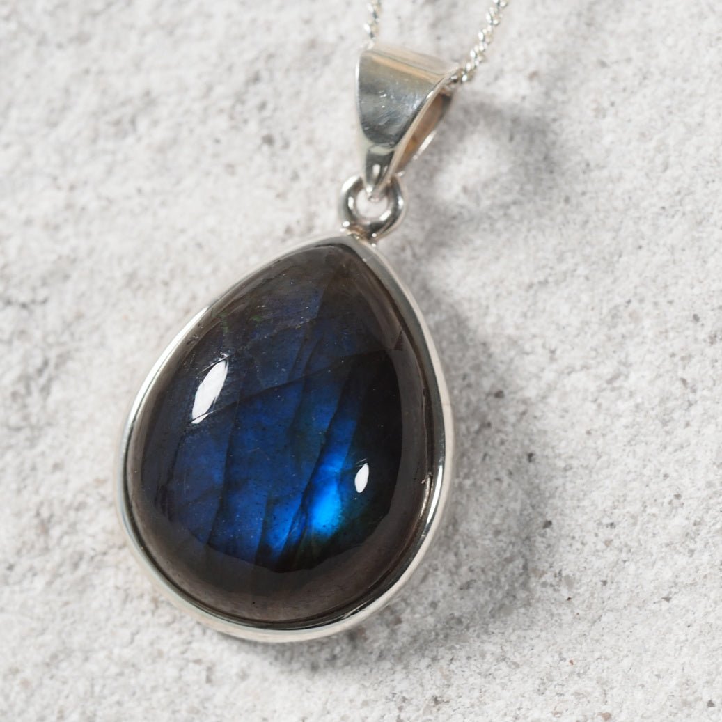 Small teardrop Labradorite pendant in polished silver bezel with subtle blue iridescence