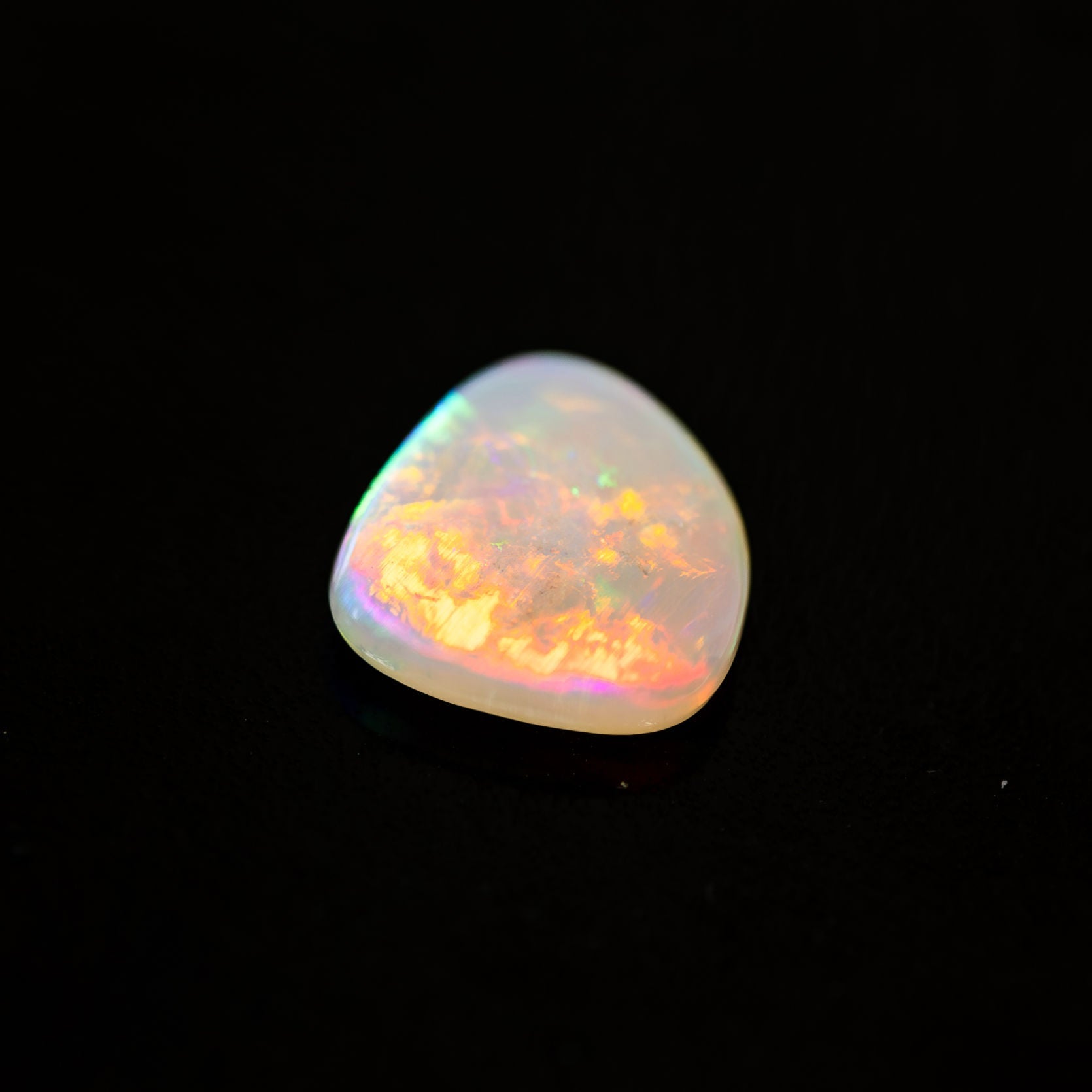 Lightning Ridge multicolored opal stone on a black background