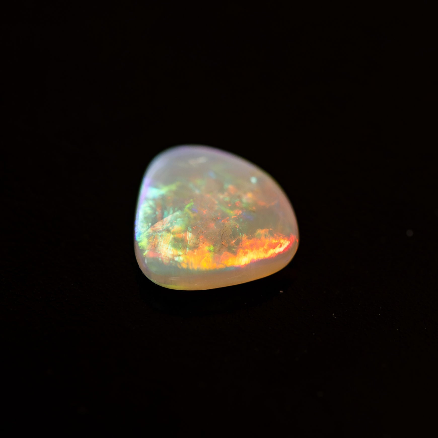 Multicolored crystal opal stone on a black background