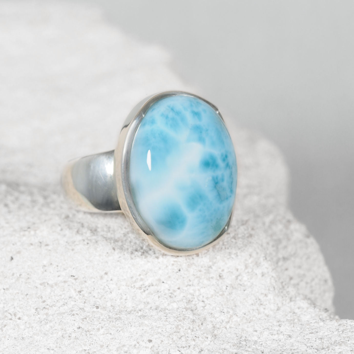 Elegant oval Larimar silver ring with gentle blue tones and subtle white patterns flowing through the stone