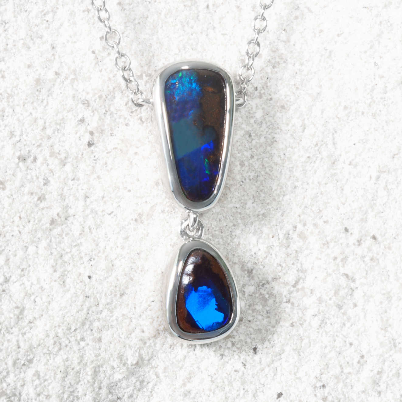 Opal pendant necklace on a textured white background