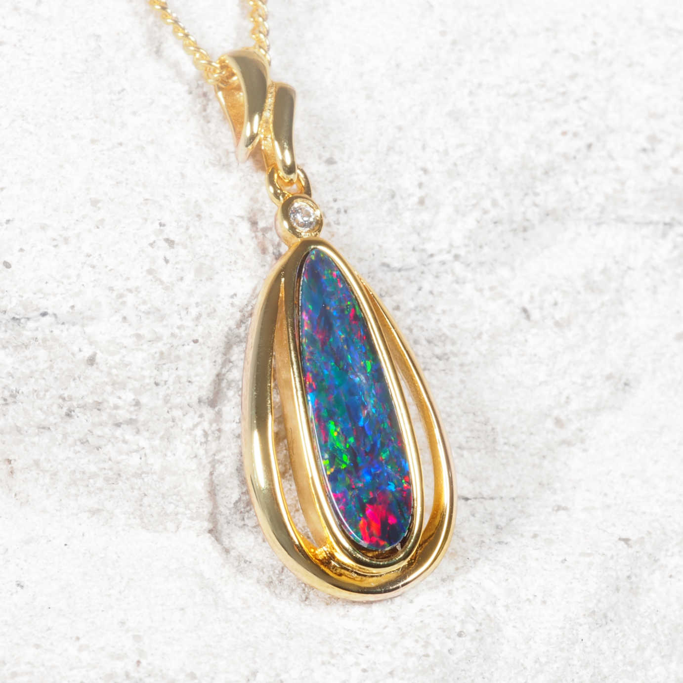 Opal pendant with gold frame on a white background