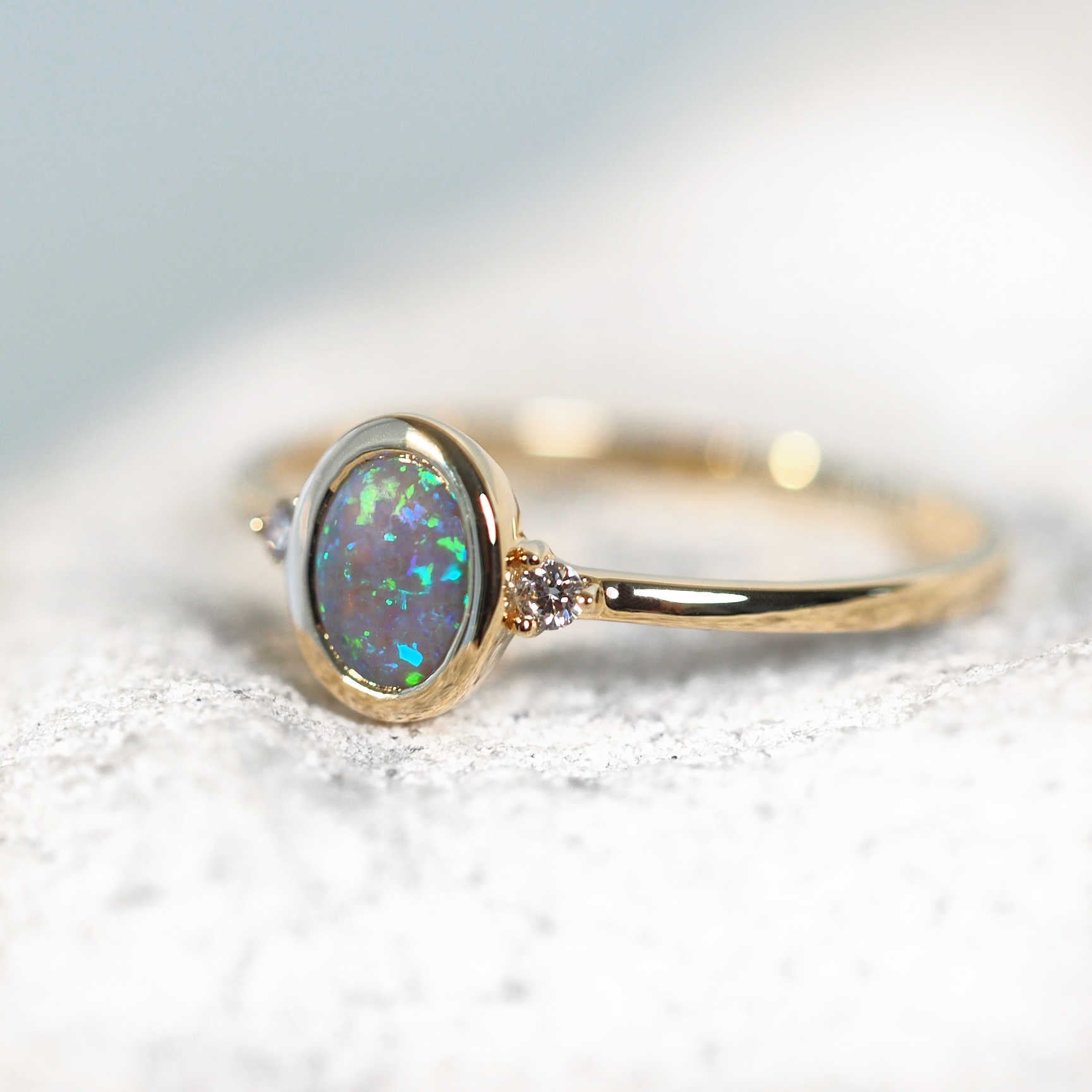 yellow gold ring set with a crystal black opal