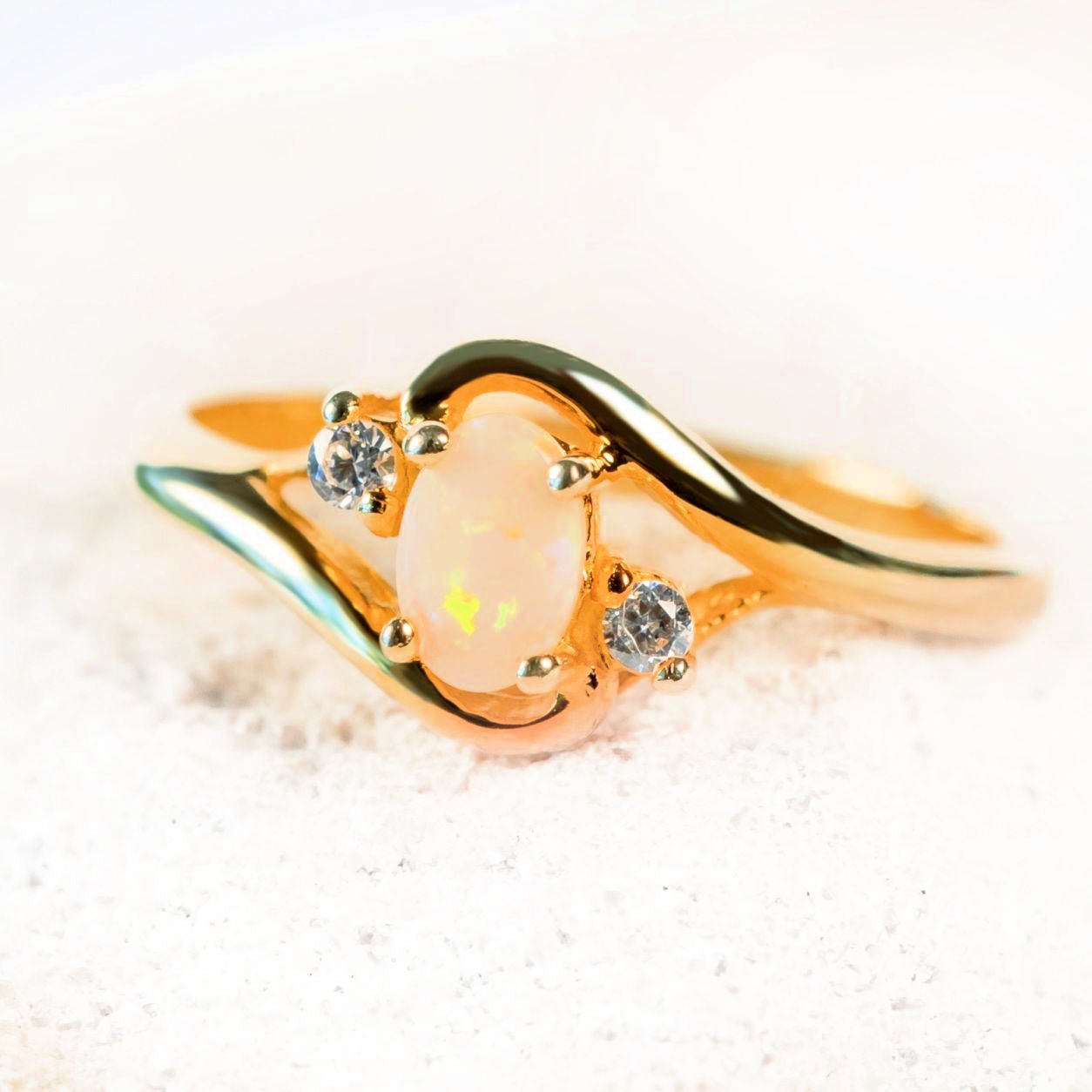 white opal gold plated ring with two sparkling cubic zirconias