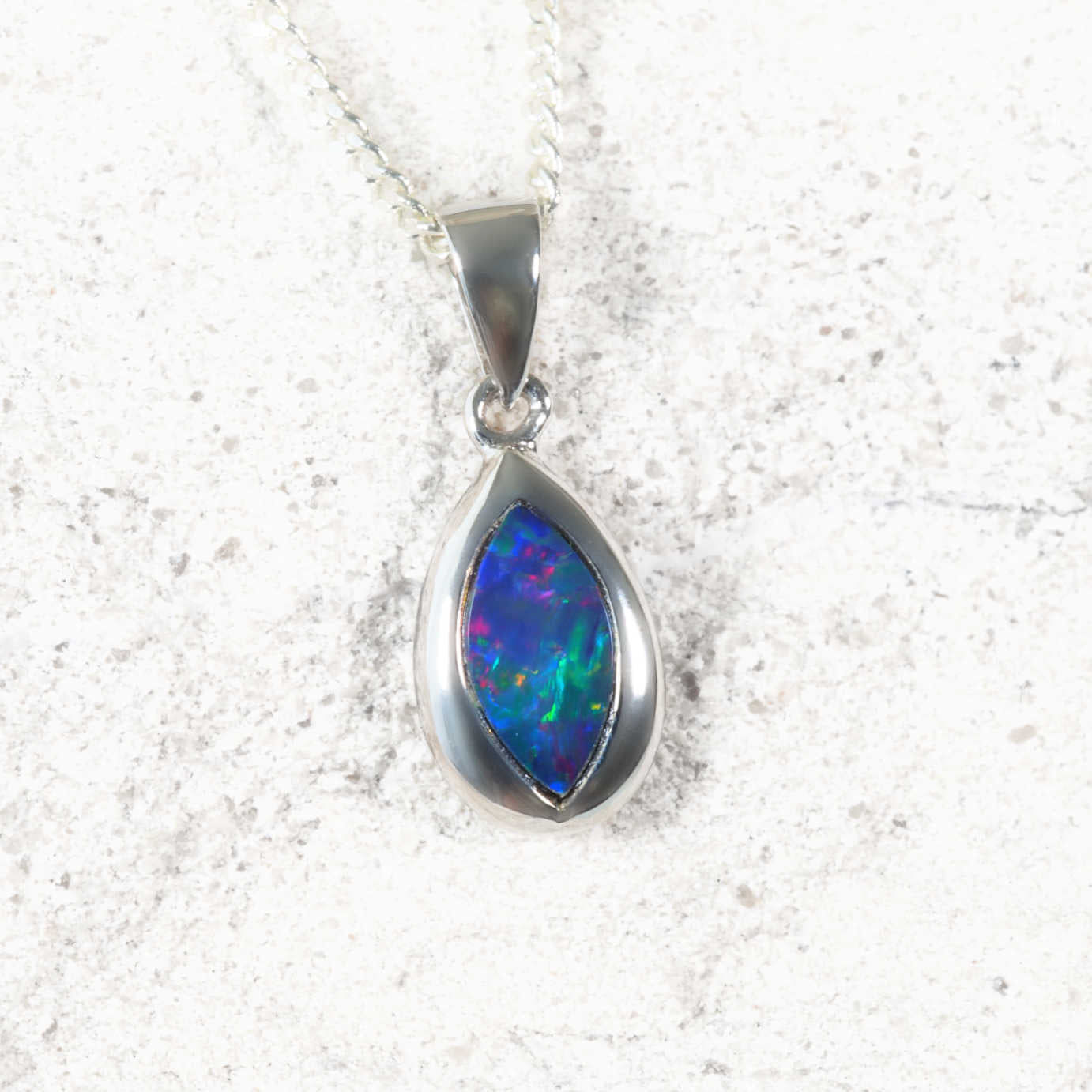 Blue opal pendant in a white gold setting on a white background