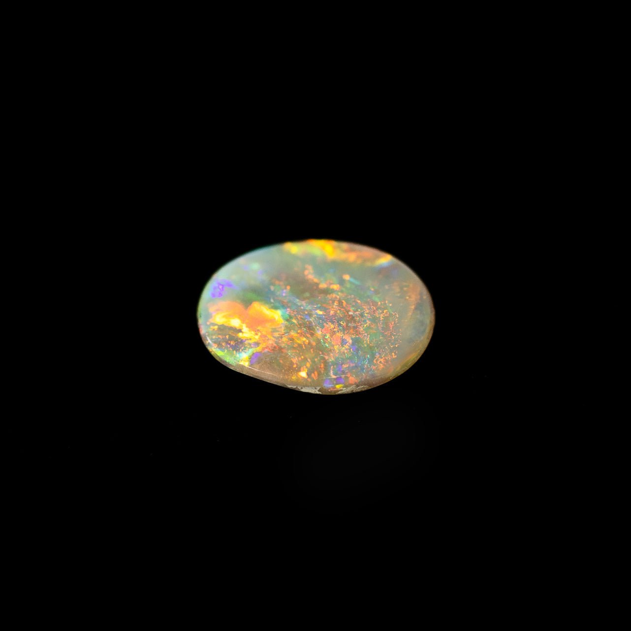 Oval-shaped Australian opal gemstone with vivid flashes of red, green, and blue