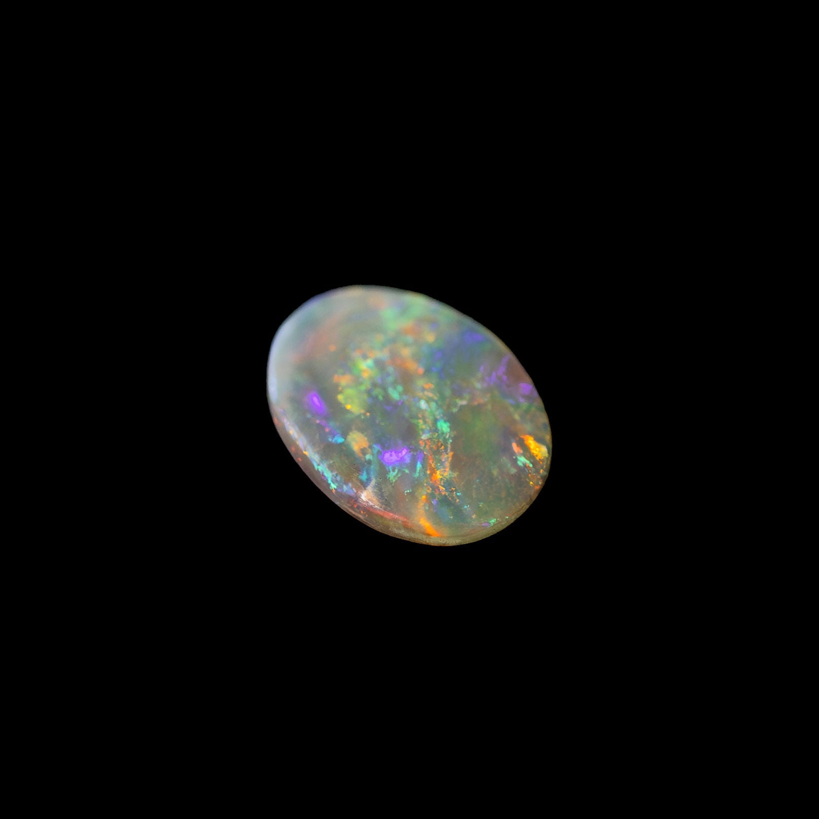 Solid Australian crystal opal showing vibrant multi-colour play-of-colour on a transparent body tone