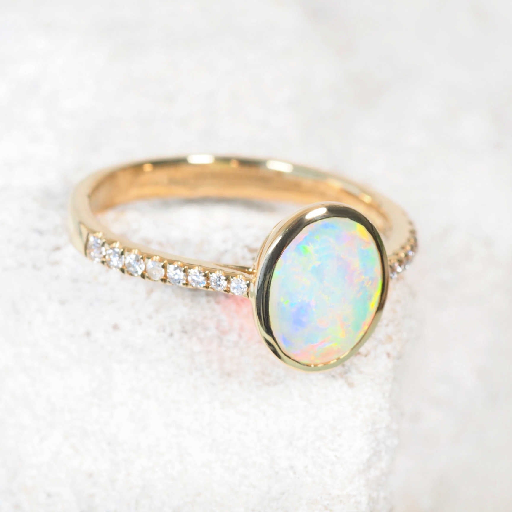Side profile of 14ct yellow gold opal and diamond ring with bezel setting