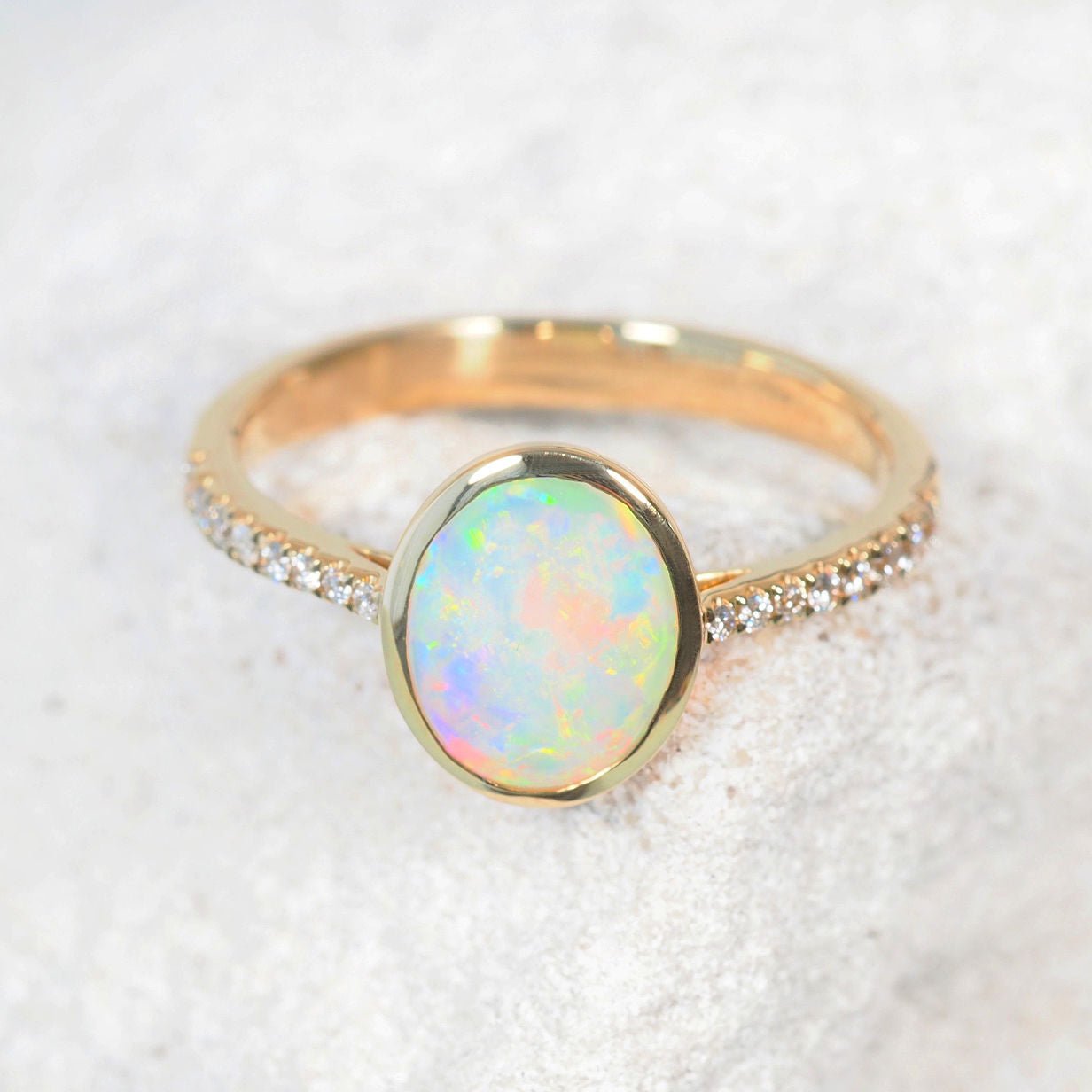 Close-up of Celeste opal ring showing oval-shaped crystal opal and diamond shoulders