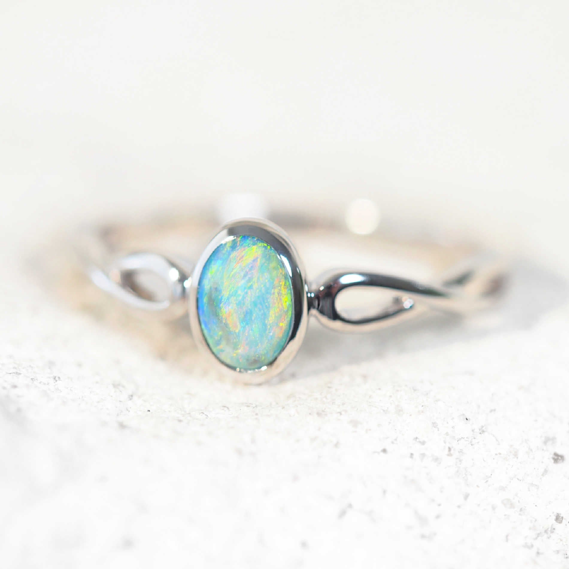 colourful oval opal ring set with a semi-black opal set in white gold