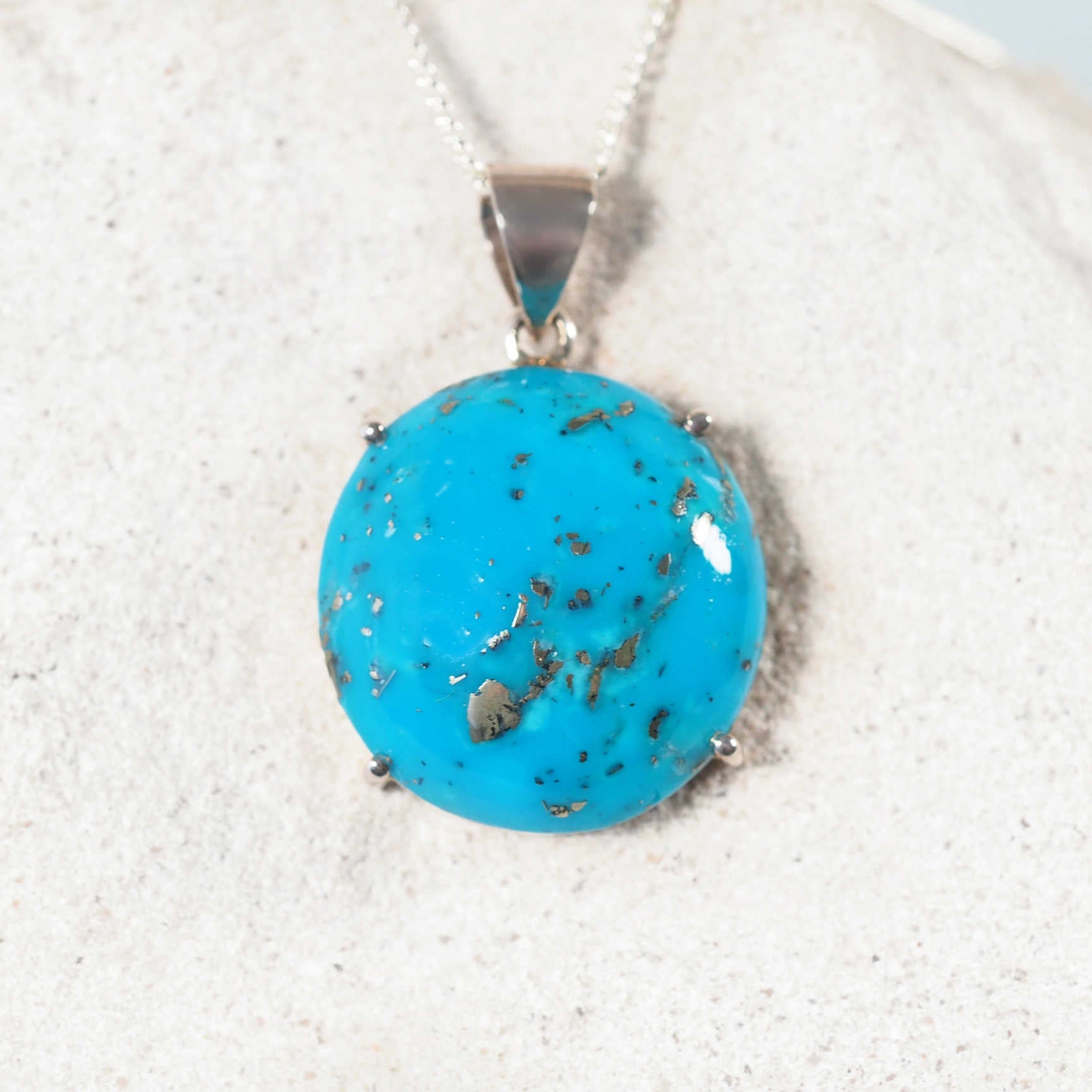 Turquoise silver pendant necklace displaying bright blue tones
