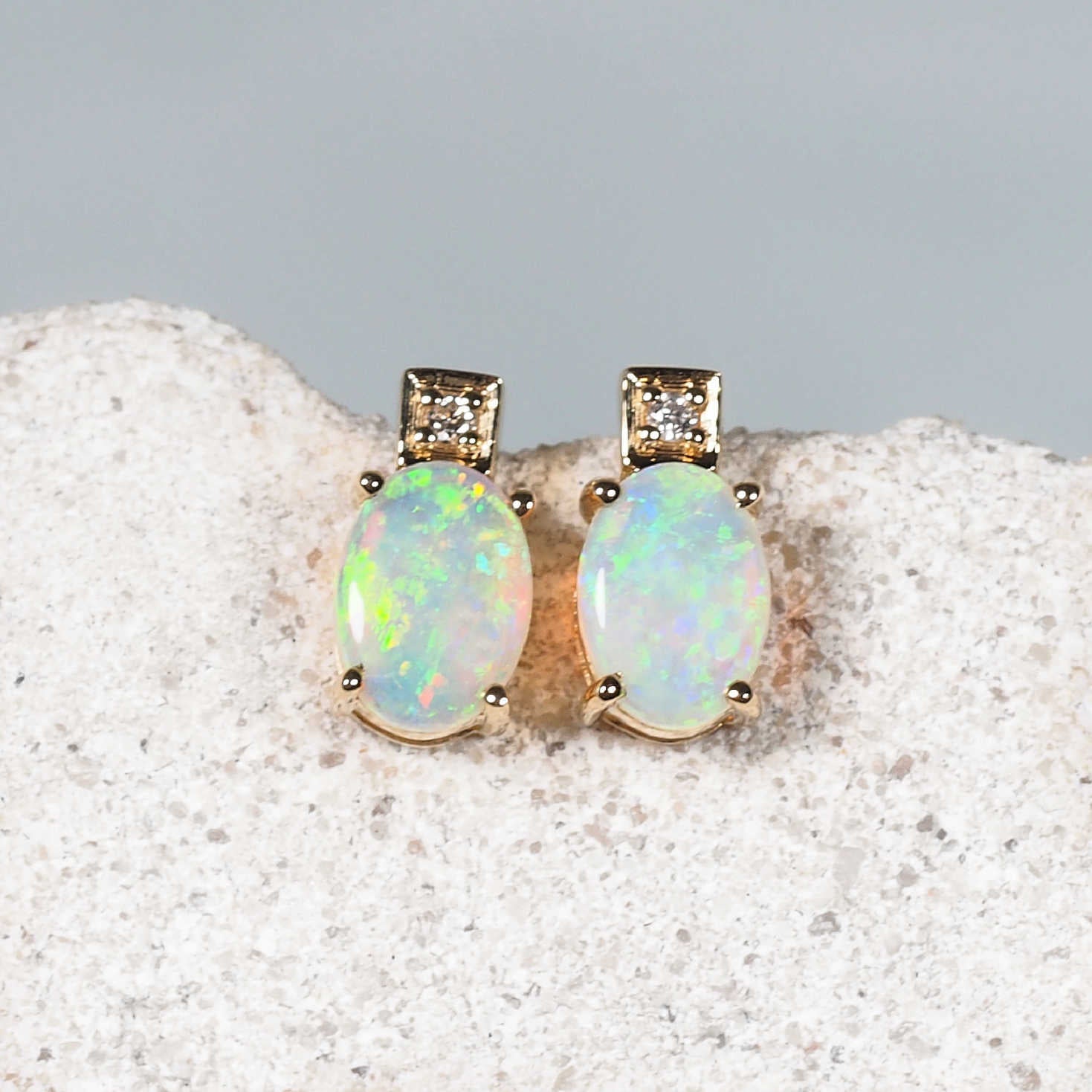 Elegant yellow gold earrings with oval Australian crystal opals and diamond accents
