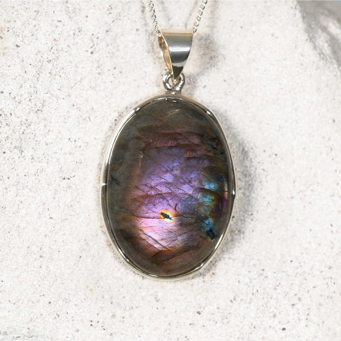 'Claire' Labradorite Pendant in polished silver, featuring a glowing round gemstone with iridescent colour play